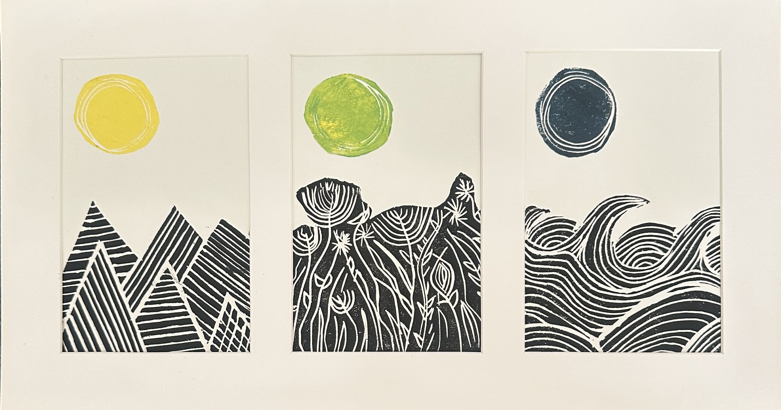 Outside, a framed triptych of linocuts showing mountains, wild plants, and waves beneath yellow, green, and black suns